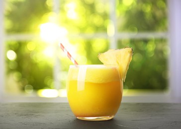 Image of Tasty pineapple cocktail in glass on wooden table indoors