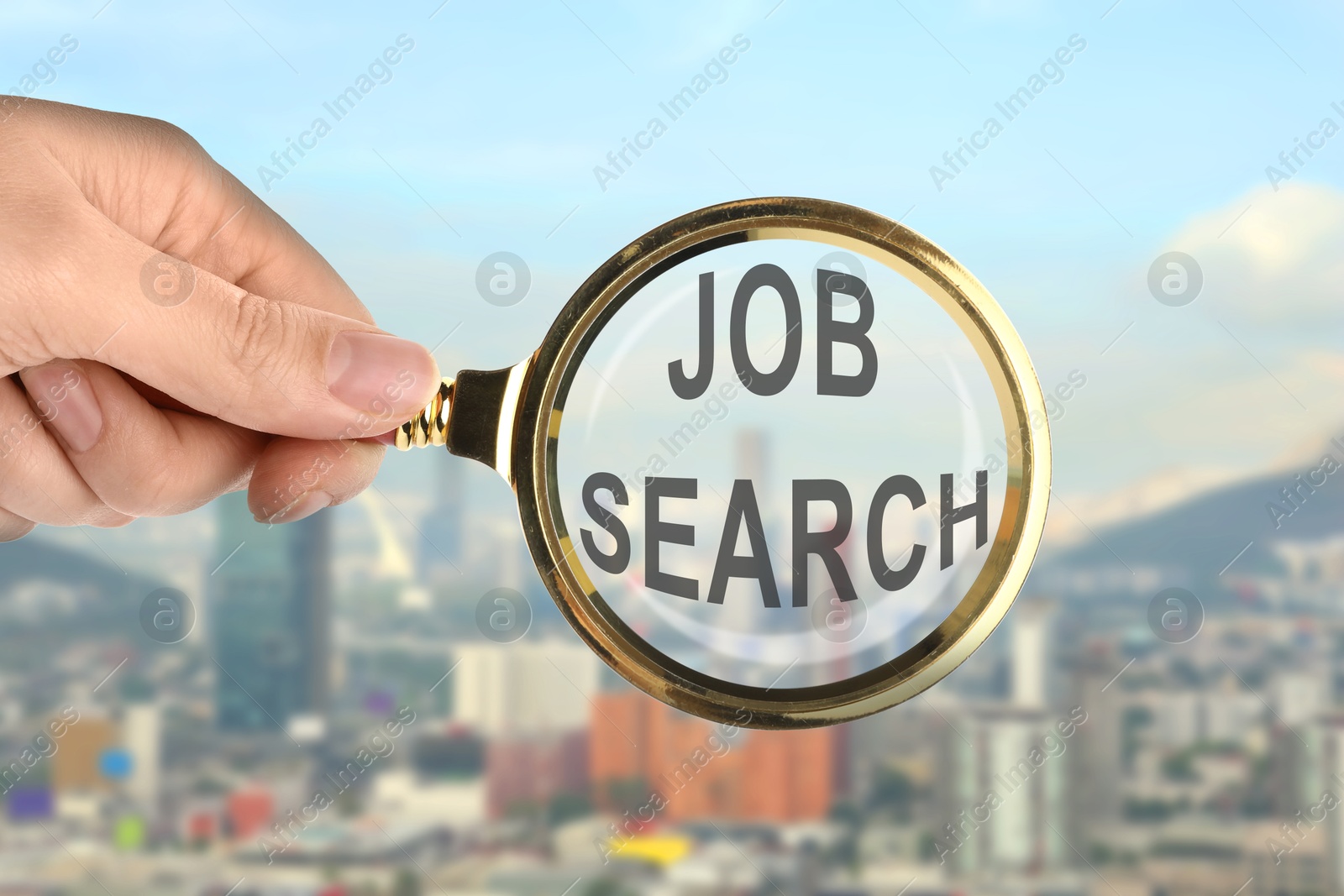 Image of Woman looking at words Job Search through magnifying glass against cityscape, closeup