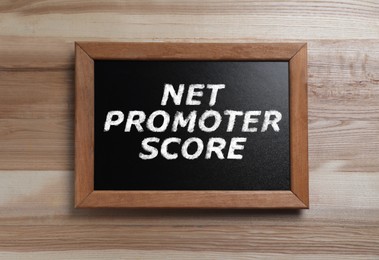 Image of Chalkboard with Net Promoter Score (NPS) on wooden background. Customer satisfaction assessment