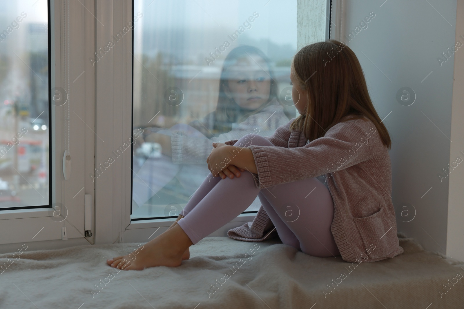 Photo of Autism concept. Lonely little girl near window at home