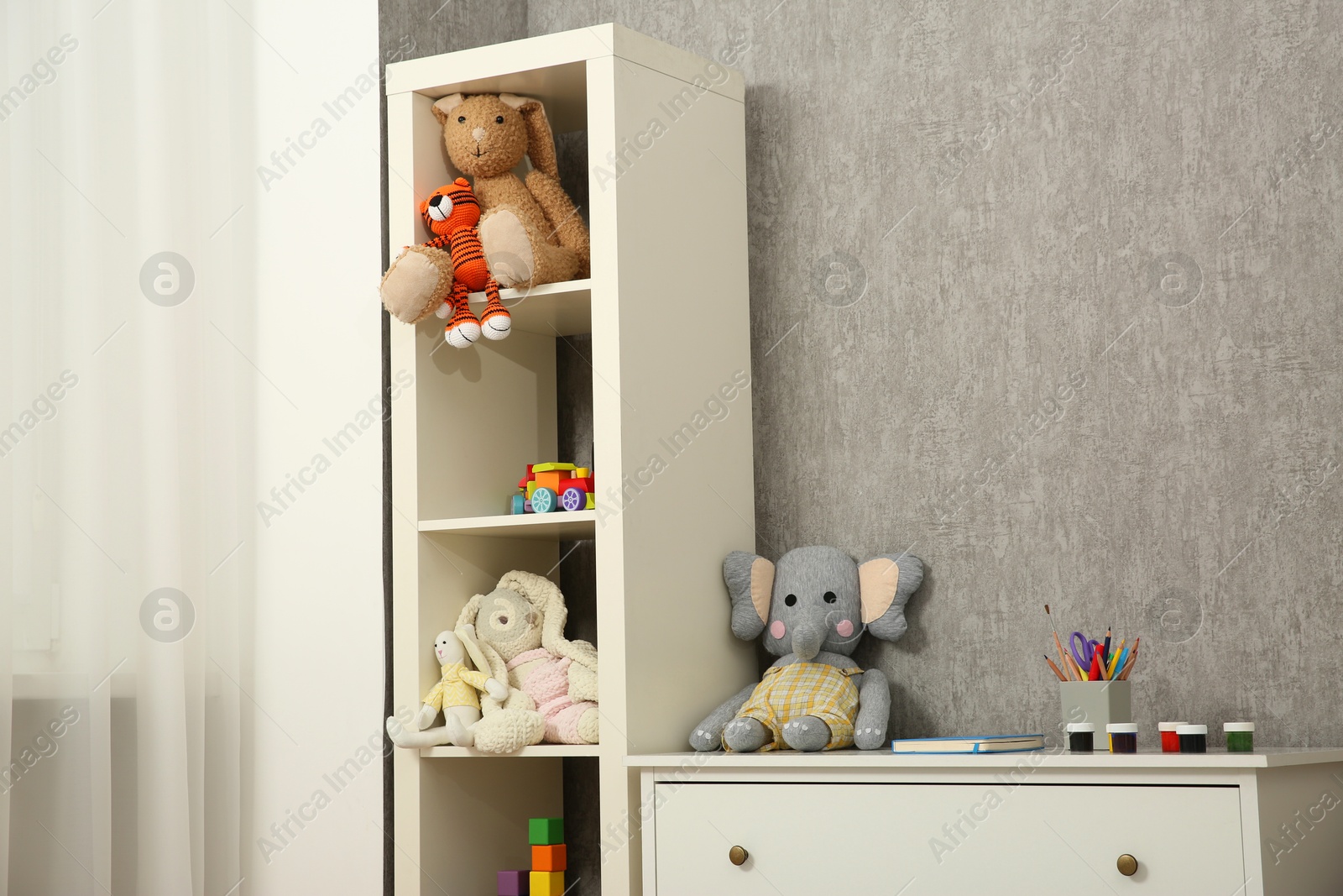 Photo of Beautiful kid's room interior with toys and stylish furniture