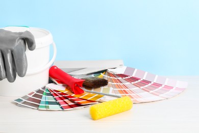 Photo of Different painter's tools on white wooden table, space for text. Decorating and design