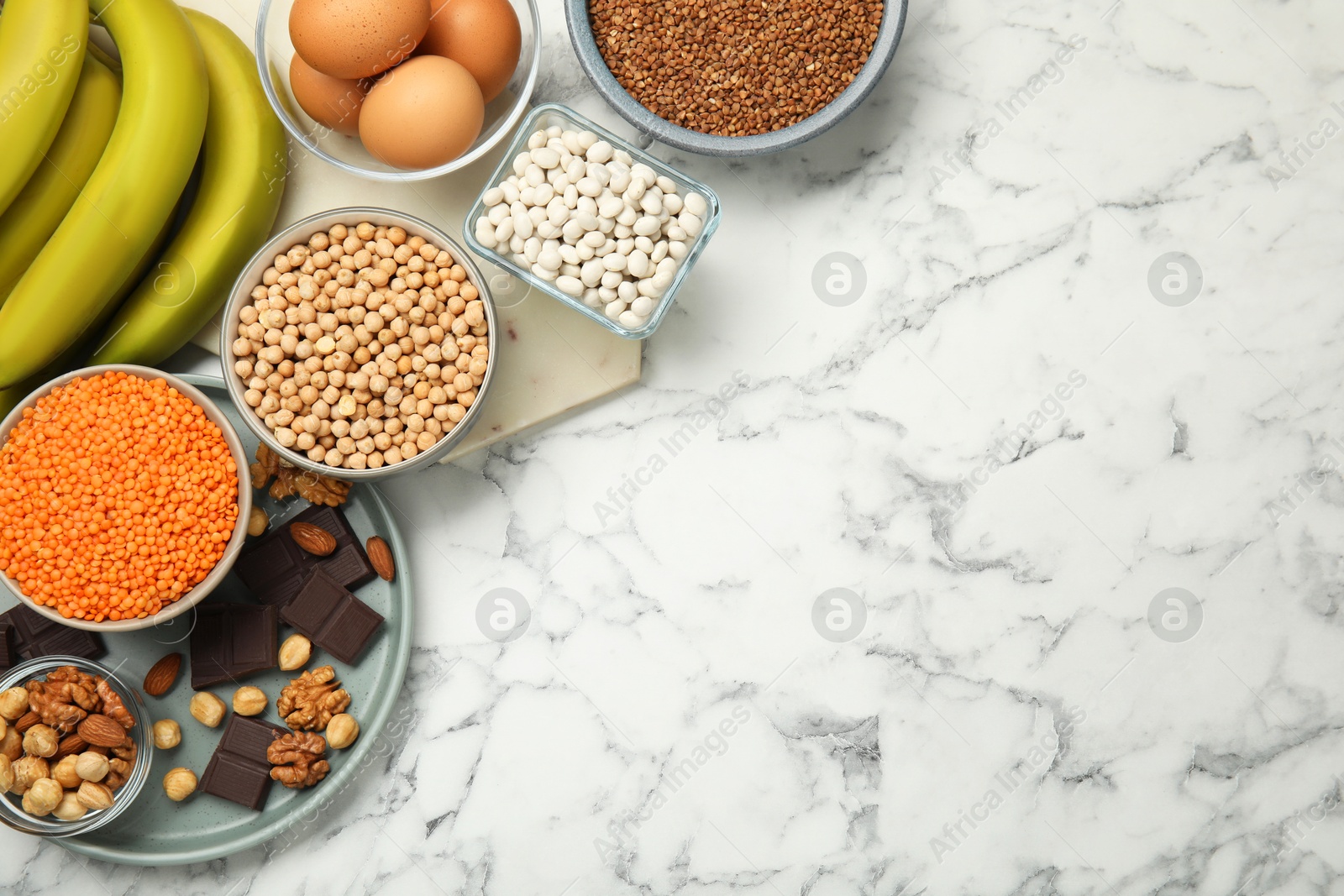 Photo of Different products rich in iron on white marble table, flat lay with space for text. Anemia diet plan