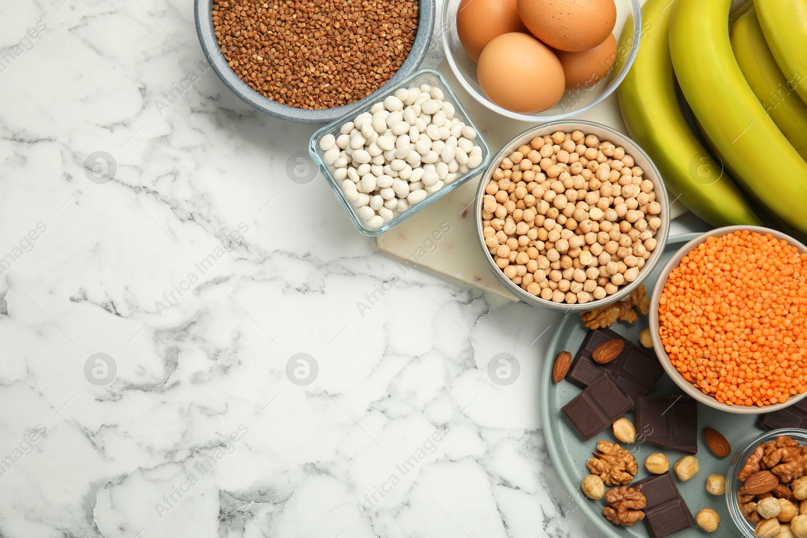 Photo of Different products rich in iron on white marble table, flat lay with space for text. Anemia diet plan