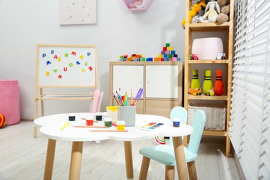 Photo of Table with paints and different toys in child's room