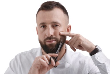 Photo of Man trimming beard with scissors on white background