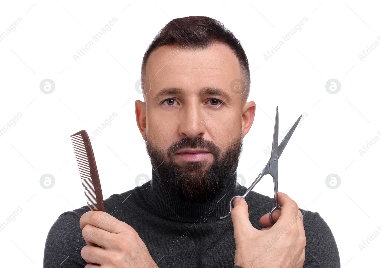 Photo of Bearded man holding comb and scissors on white background