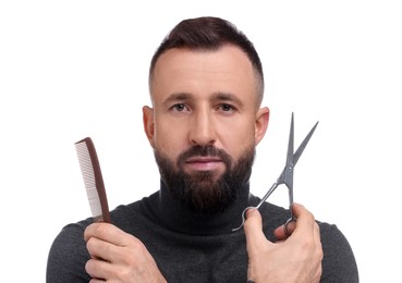 Bearded man holding comb and scissors on white background