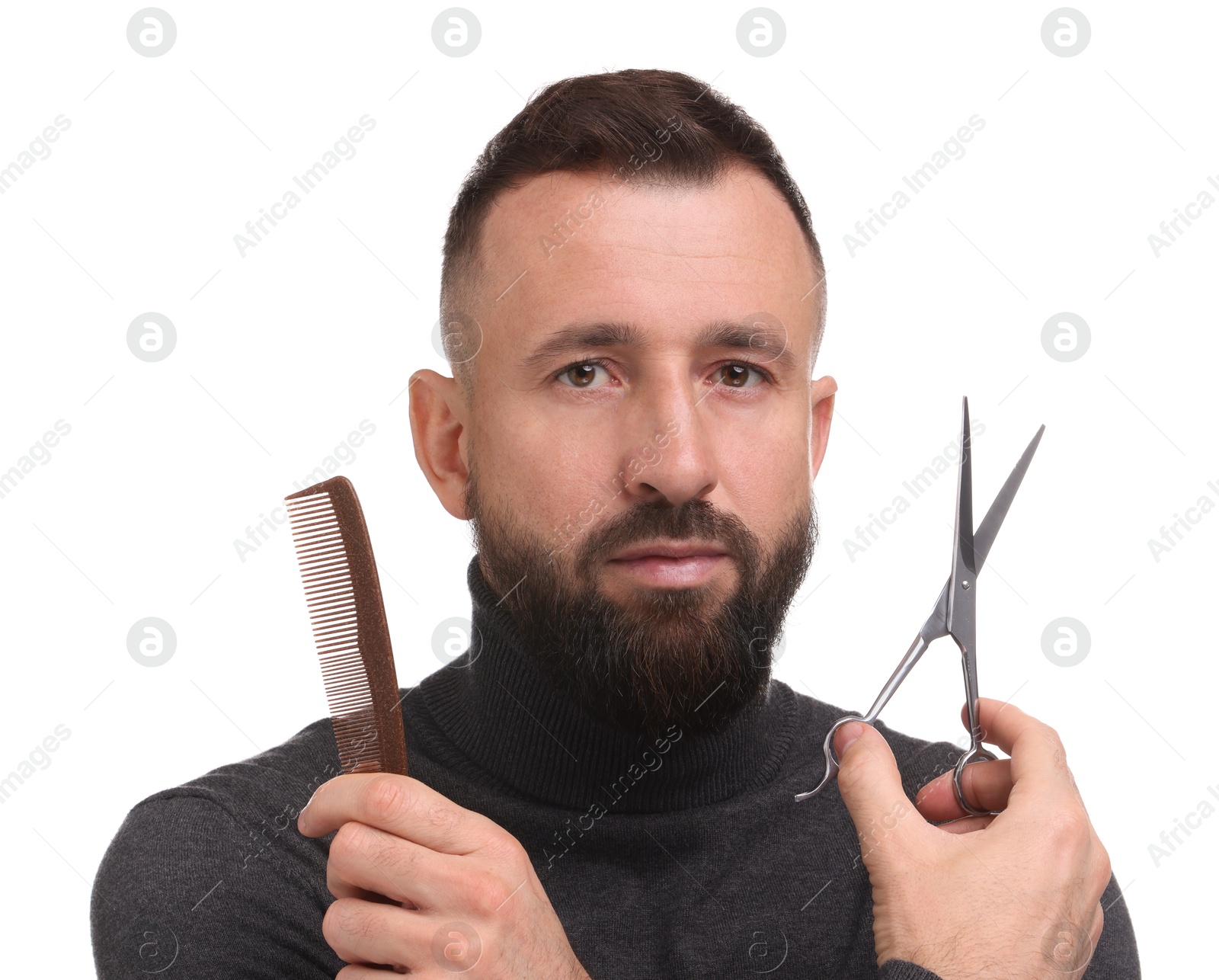 Photo of Bearded man holding comb and scissors on white background