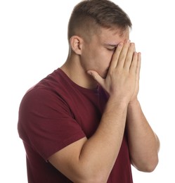 Distressed young man crying on white background