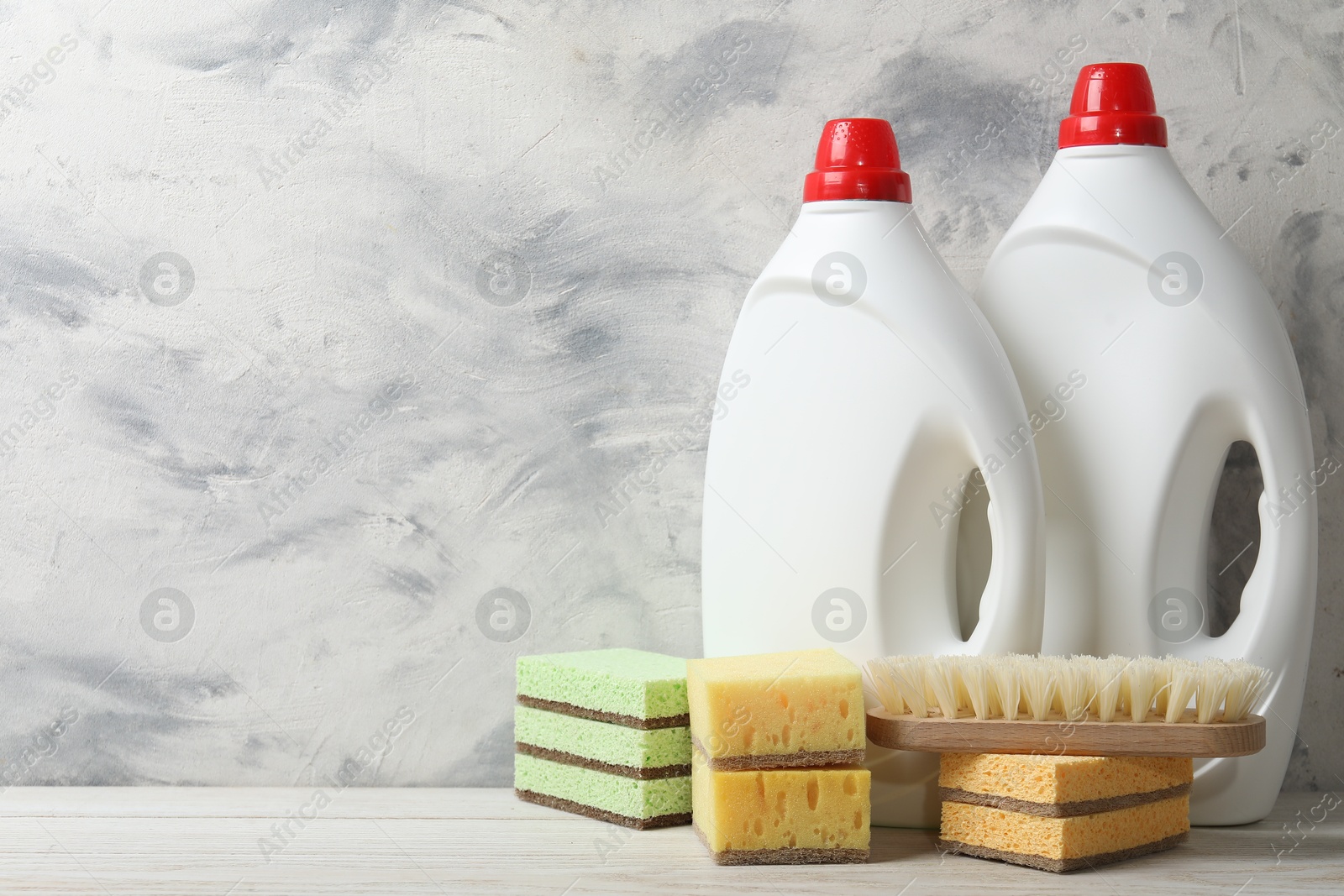 Photo of Eco-friendly cleaning products and supplies on light wooden table, space for text