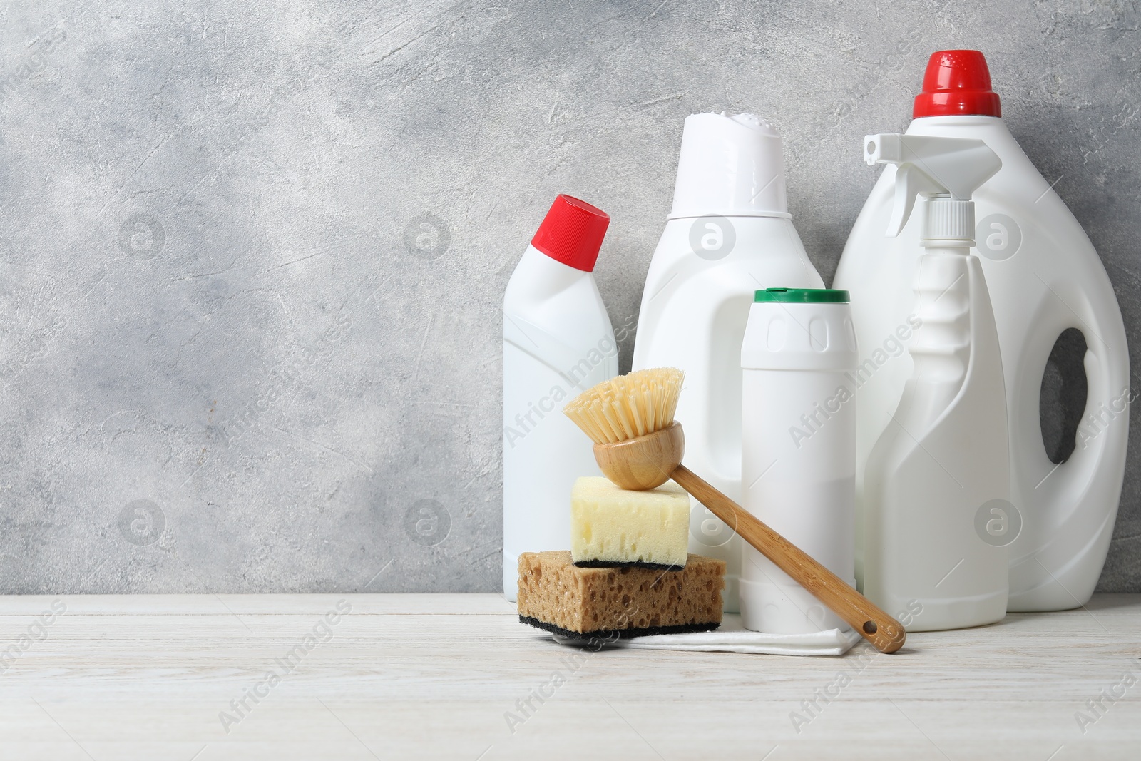 Photo of Eco-friendly cleaning products and supplies on light wooden table, space for text