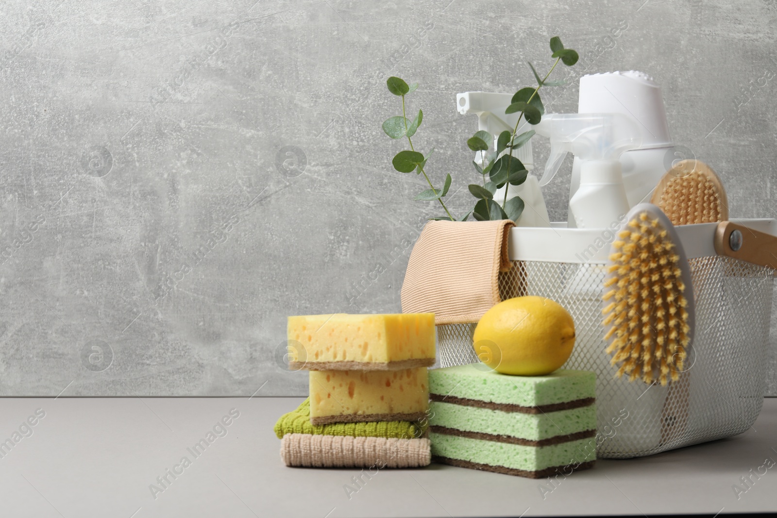 Photo of Eco-friendly cleaning products, supplies and eucalyptus branches on grey table, space for text