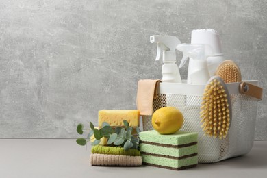 Photo of Eco-friendly cleaning products, supplies and eucalyptus branches on grey table, space for text