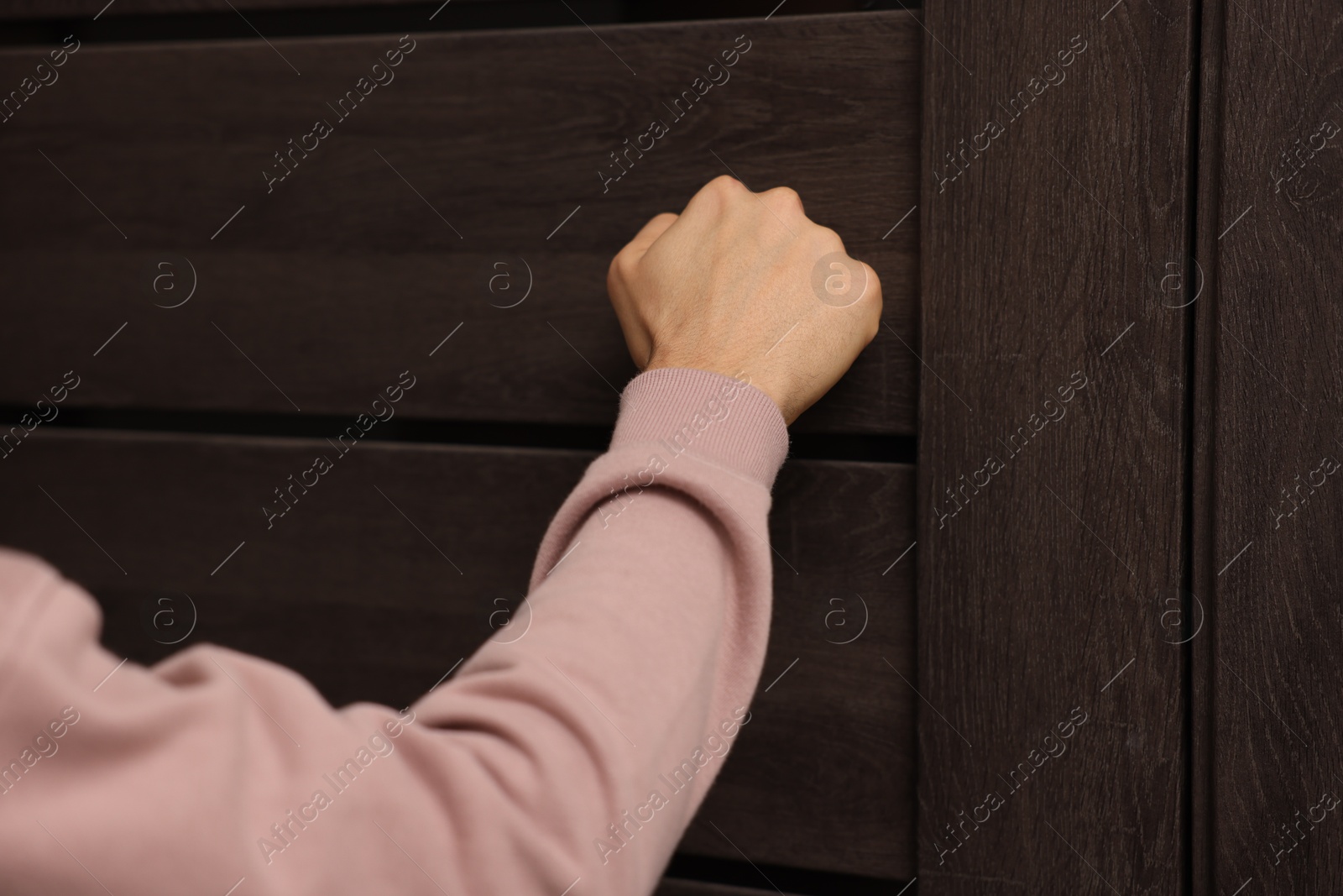 Photo of Man knocking on door to his friends apartment, closeup