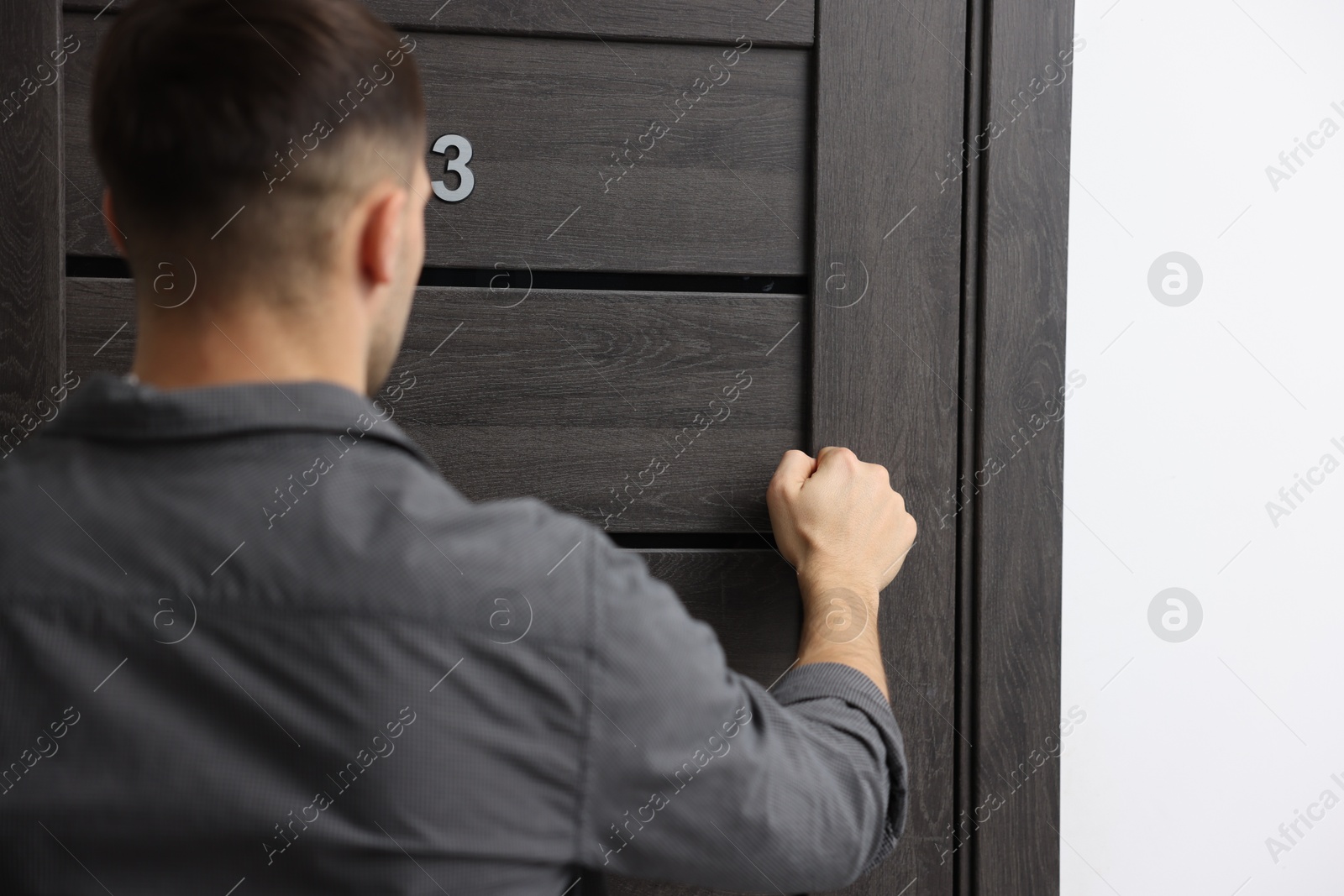 Photo of Man knocking on door to his friends apartment