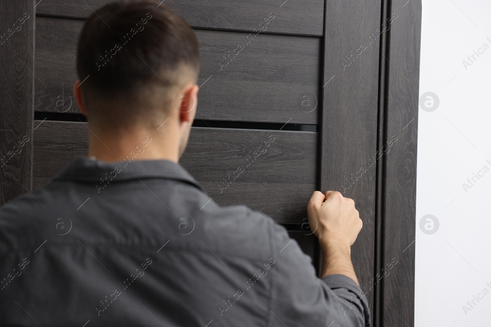 Photo of Man knocking on door to his friends apartment