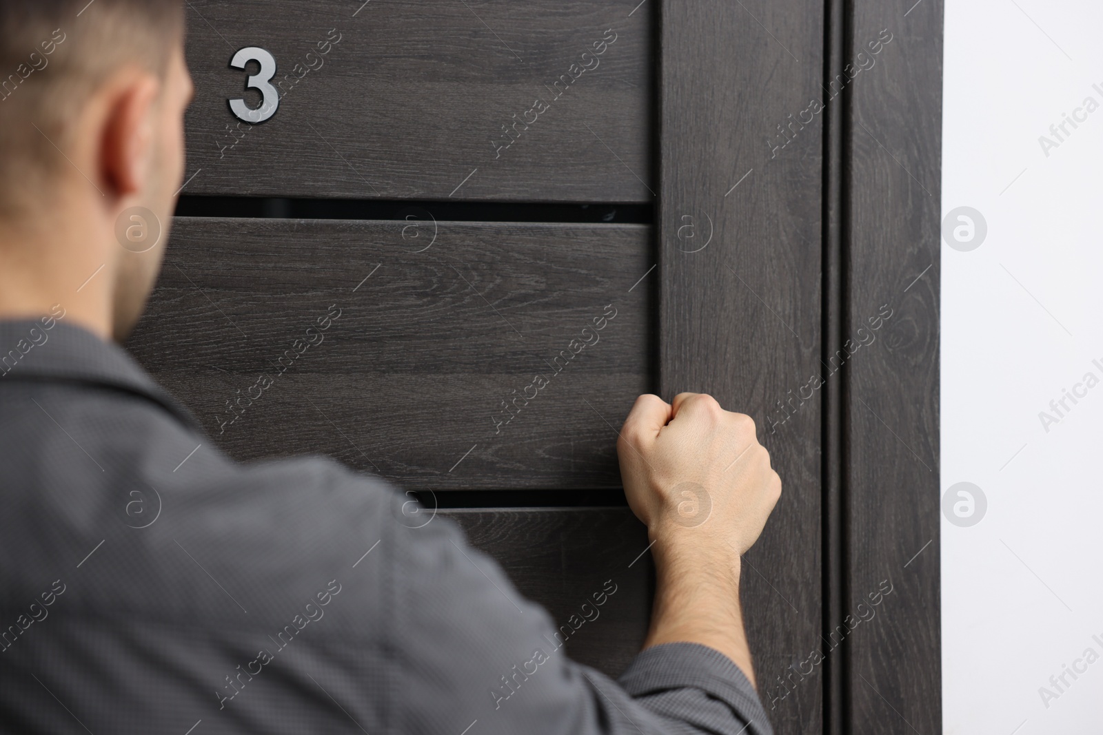 Photo of Man knocking on door to his friends apartment, closeup