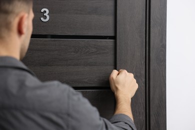 Photo of Man knocking on door to his friends apartment, closeup