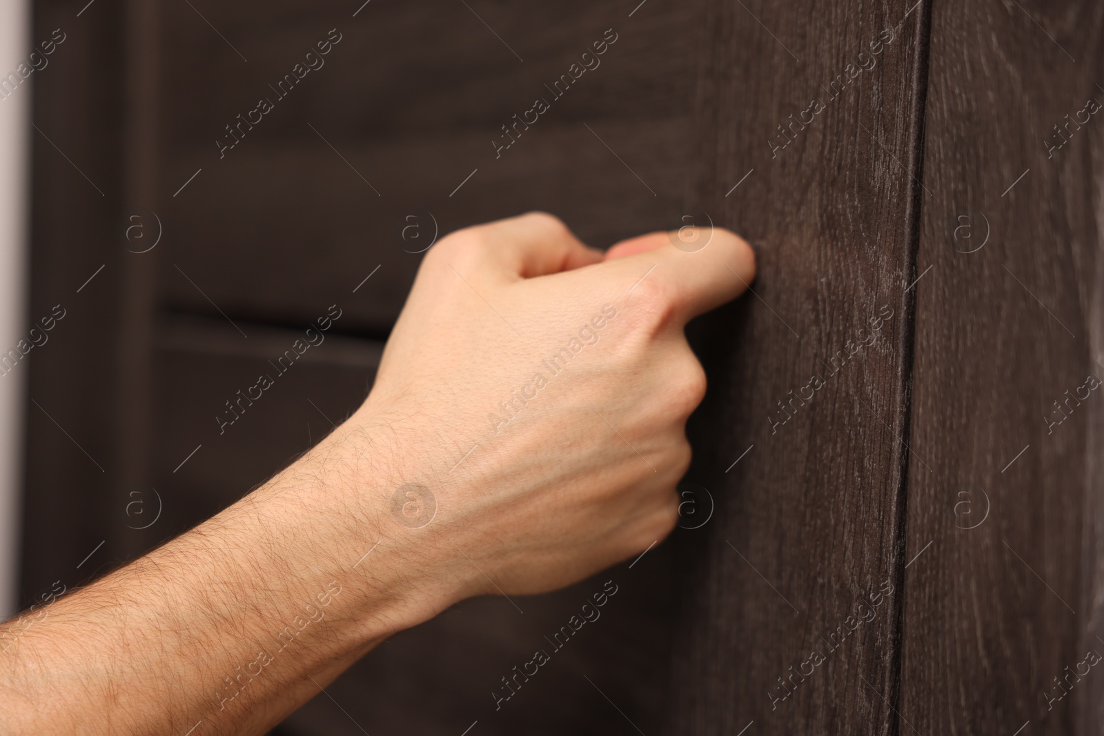 Photo of Man knocking on door to his friends apartment, closeup