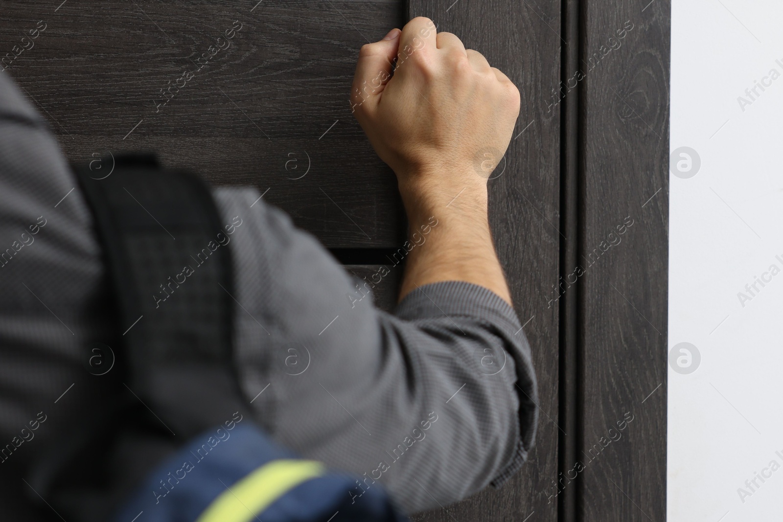 Photo of Man knocking on door to his friends apartment, closeup