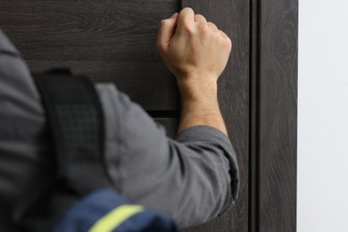 Photo of Man knocking on door to his friends apartment, closeup