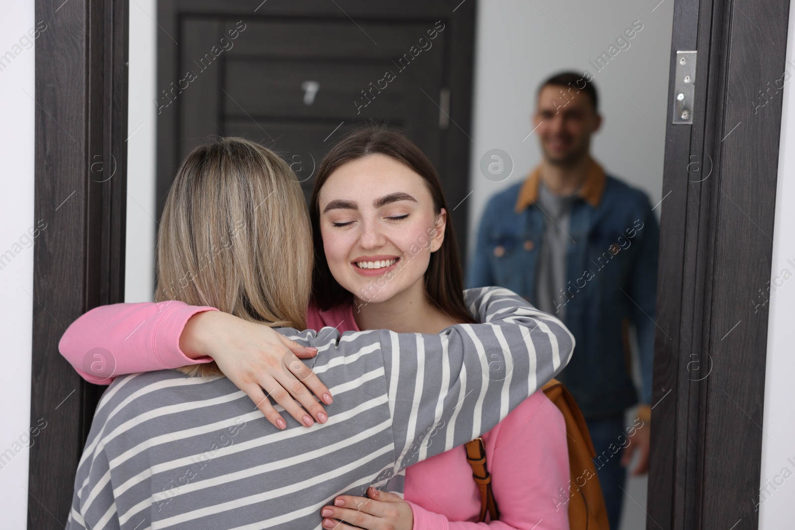 Photo of Woman welcoming friends to her new apartment