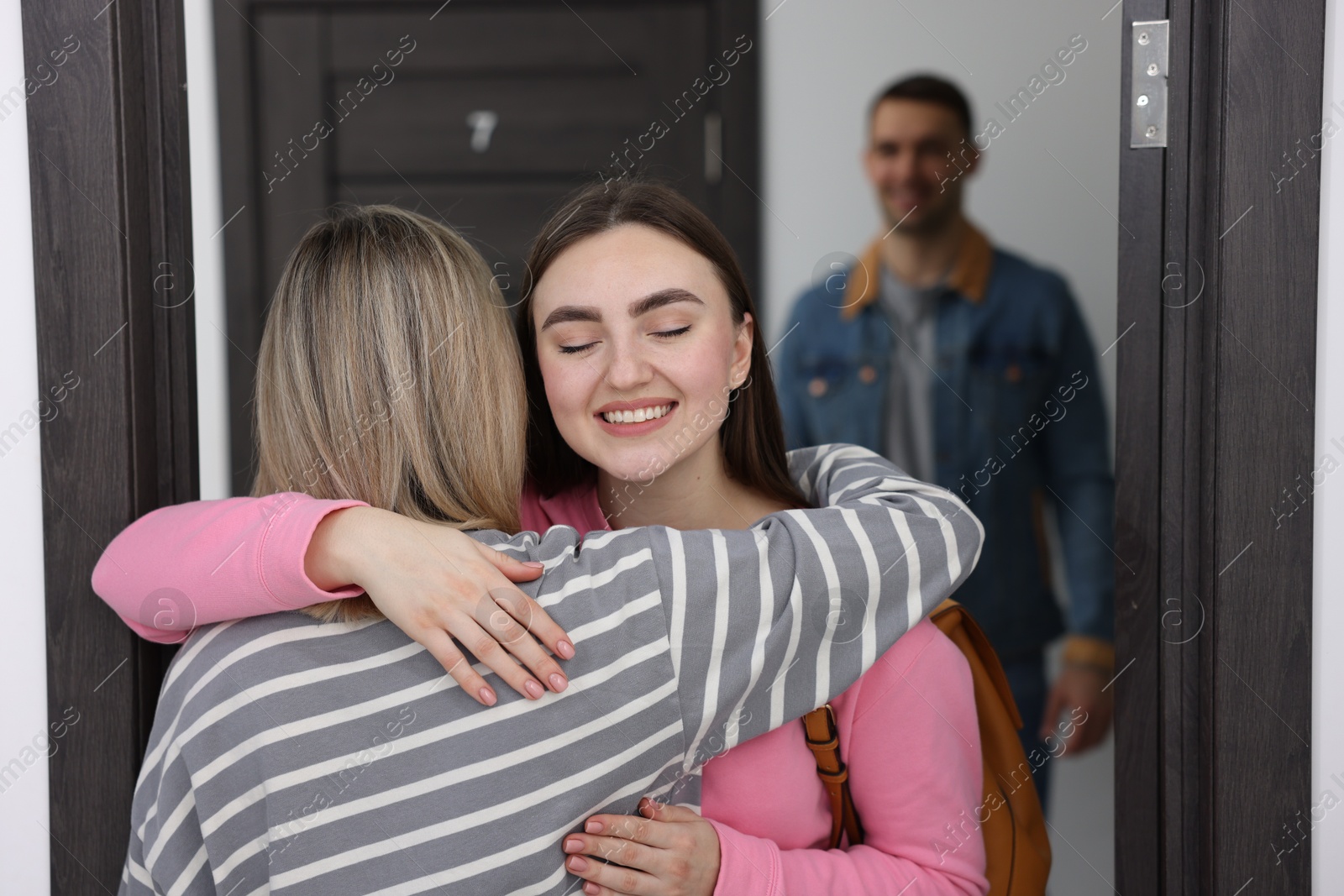 Photo of Woman welcoming friends to her new apartment