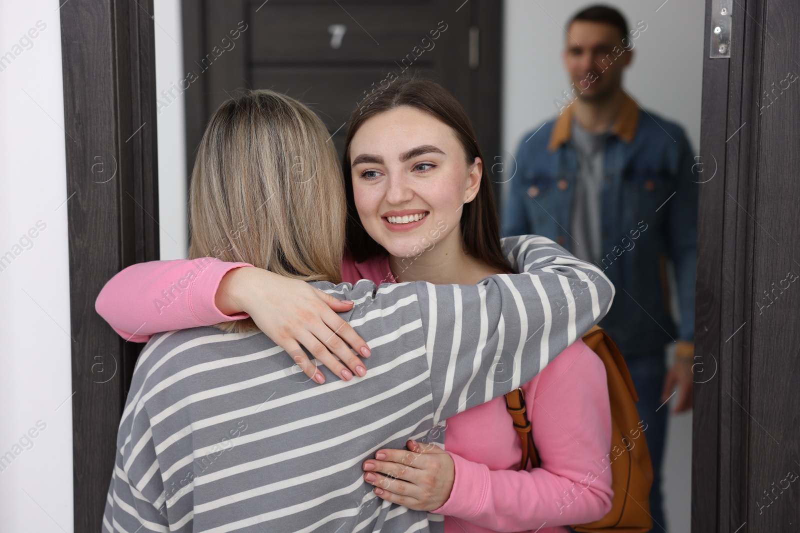 Photo of Woman welcoming friends to her new apartment