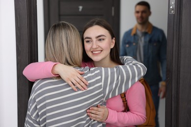 Photo of Woman welcoming friends to her new apartment