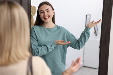 Photo of Happy woman welcoming guest to her apartment