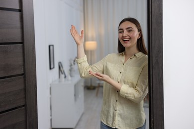 Photo of Happy woman welcoming guests to her house