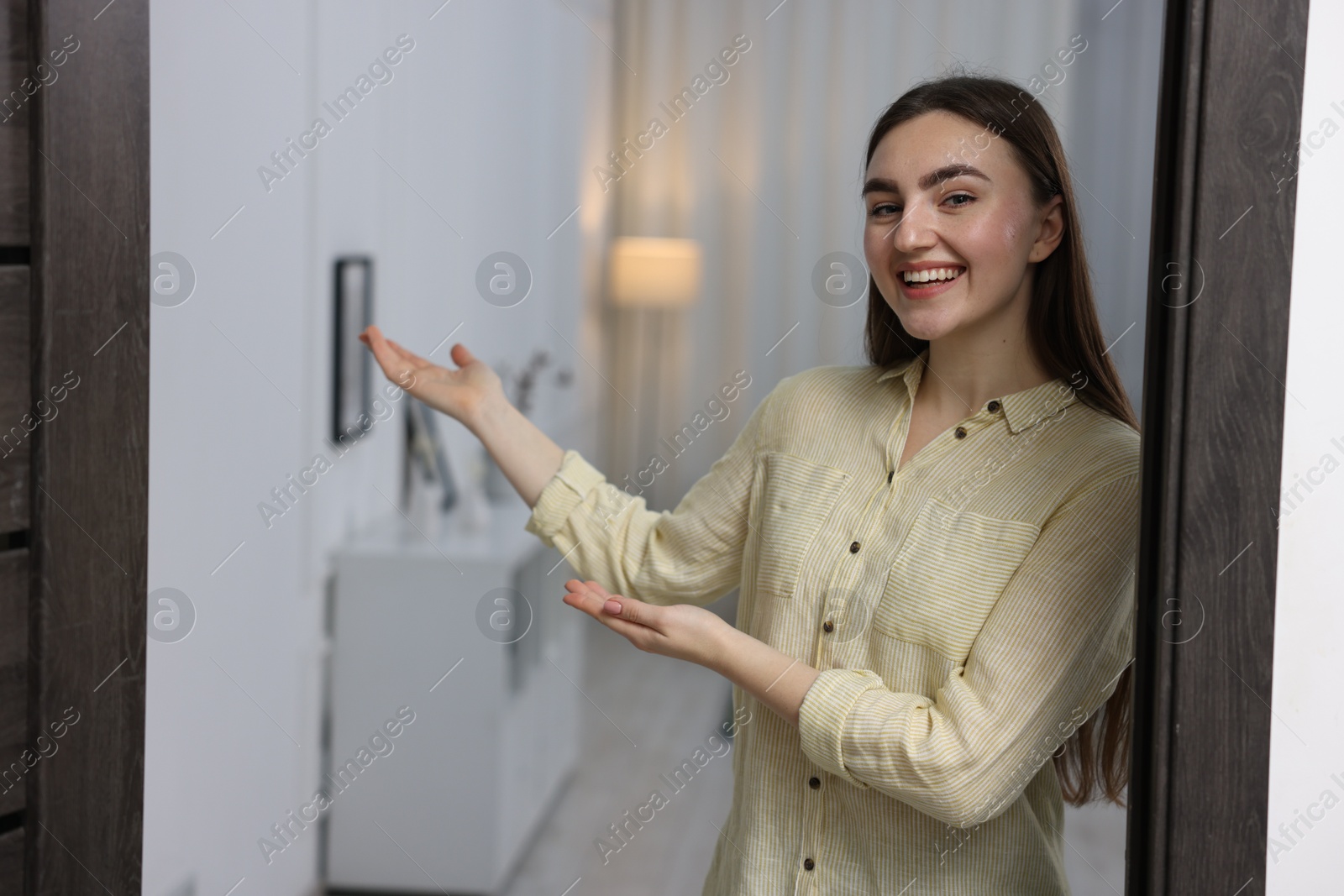 Photo of Happy woman welcoming guests to her house