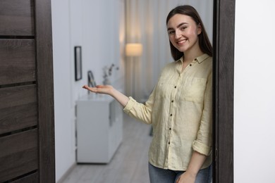 Photo of Happy woman welcoming guests to her house