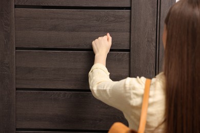 Woman knocking on door of her friends apartment, closeup