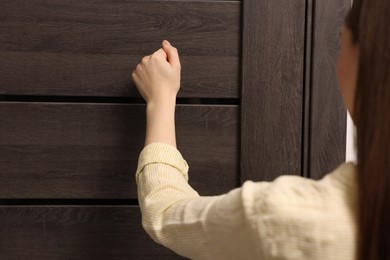 Photo of Woman knocking on door of her friends apartment, closeup