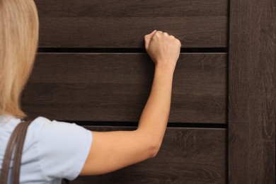 Photo of Woman knocking on door of her friends apartment, closeup