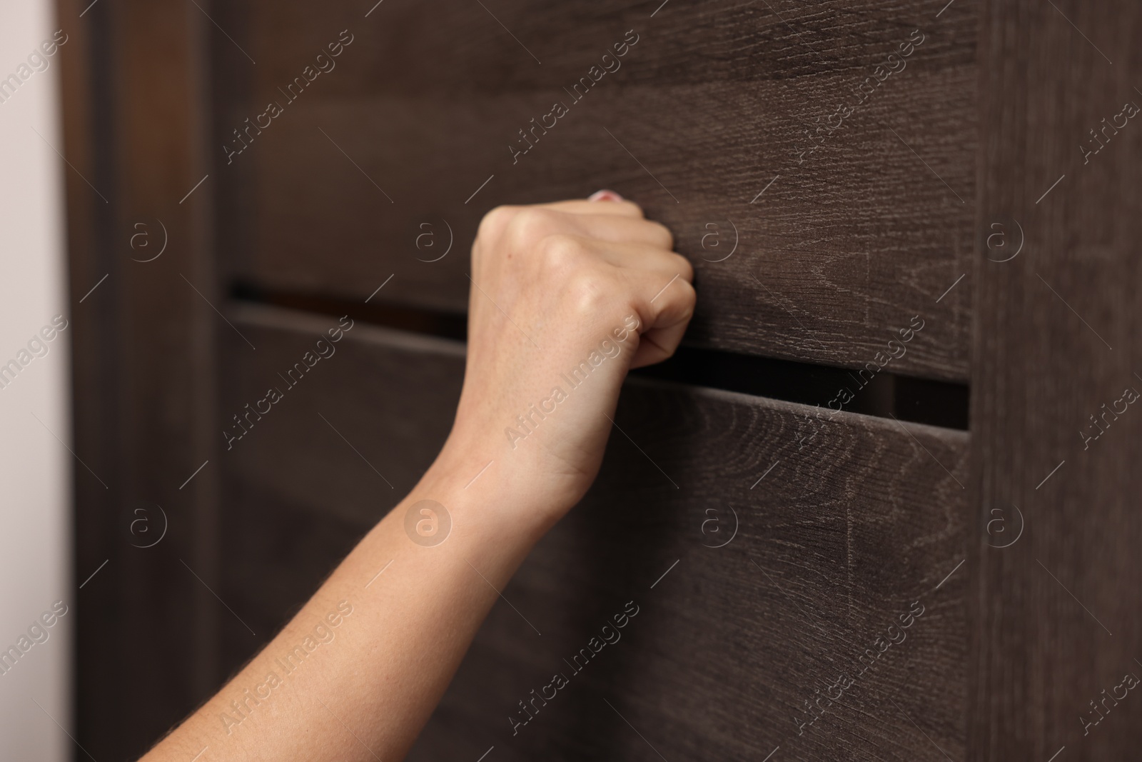 Photo of Woman knocking on door of her friends apartment, closeup