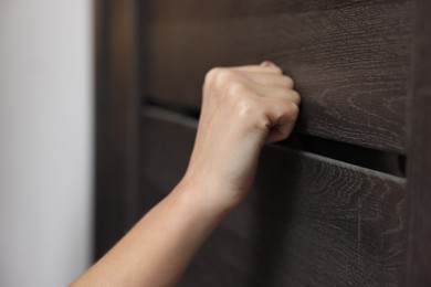 Photo of Woman knocking on door of her friends apartment, closeup