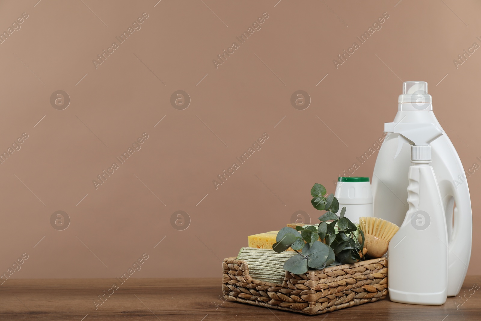 Photo of Eco-friendly cleaning products, supplies and eucalyptus branches on wooden table, space for text