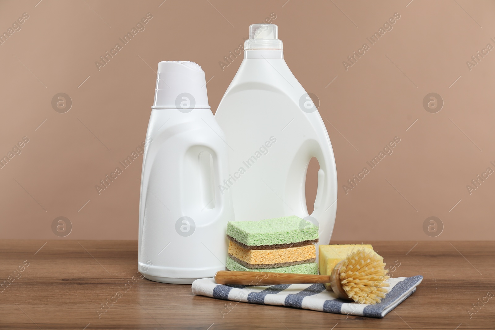 Photo of Eco-friendly cleaning products and supplies on wooden table against beige background