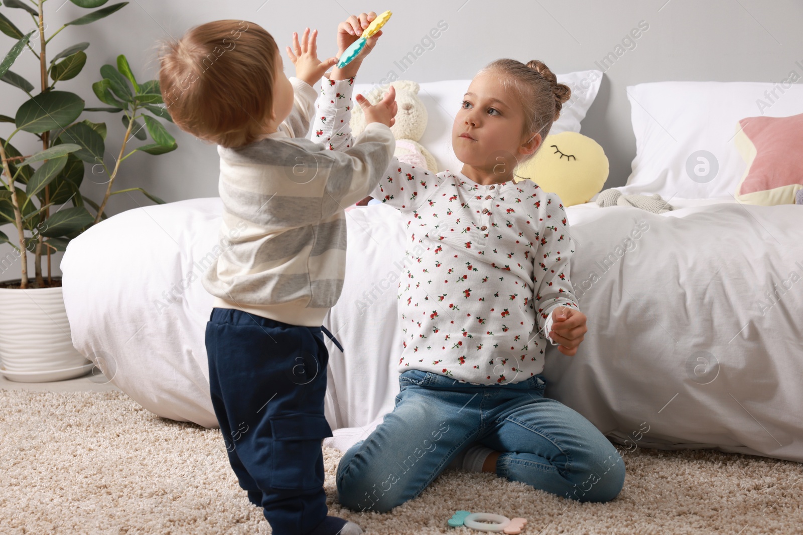 Photo of Sister and brother spending time together on floor indoors