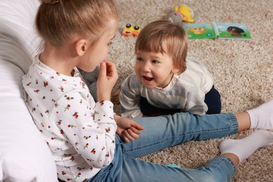 Sister and brother spending time together on floor at home