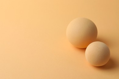 Photo of Two textured balls on beige background, space for text