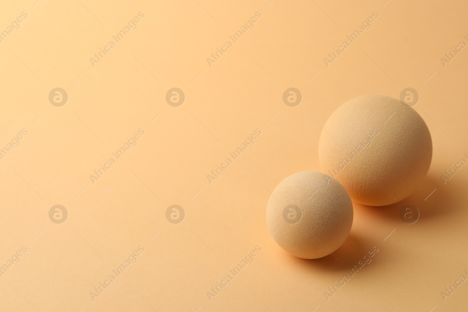 Photo of Two textured balls on beige background, space for text