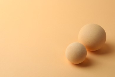 Photo of Two textured balls on beige background, space for text