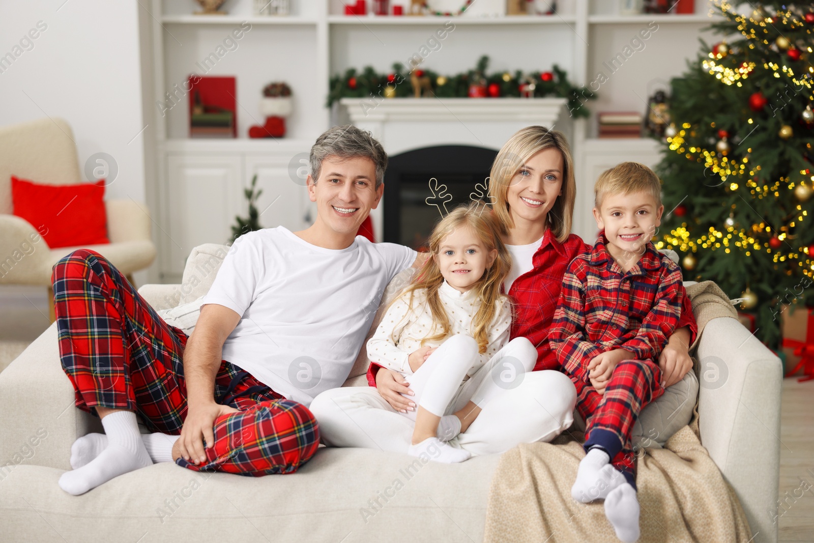 Photo of Happy family in pajamas on sofa at home. Christmas morning