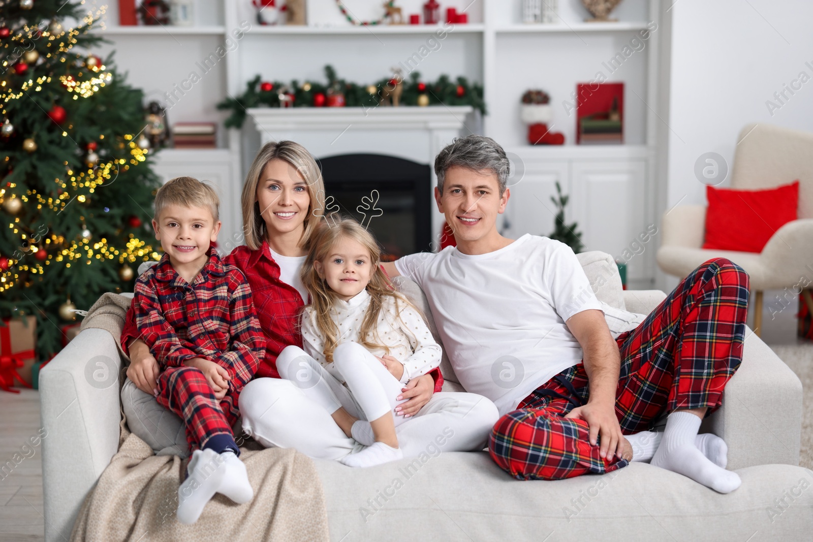 Photo of Happy family in pajamas on sofa at home. Christmas morning