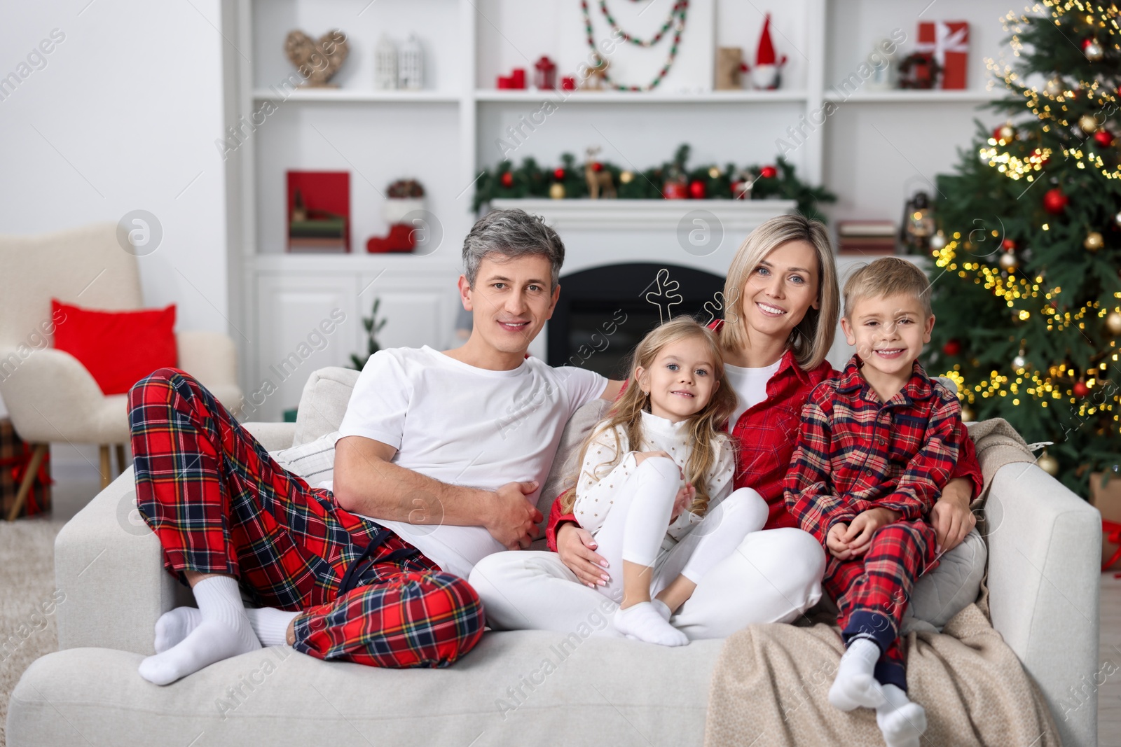 Photo of Happy family in pajamas on sofa at home. Christmas morning