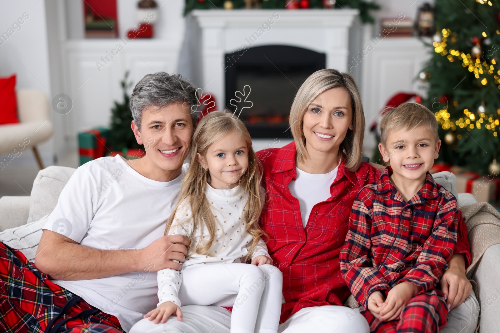 Photo of Happy family in pajamas on sofa at home. Christmas morning